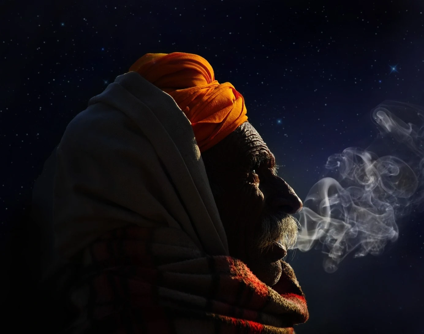 Man with an orange turban in profile, smoke drifting into a starry night sky